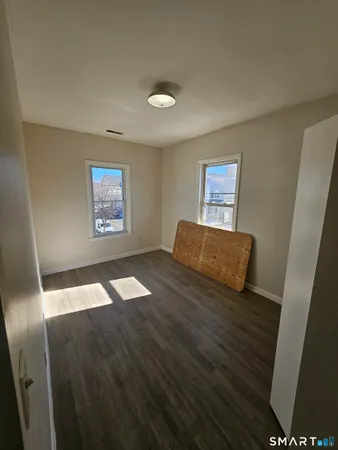 a view of empty room with wooden floor