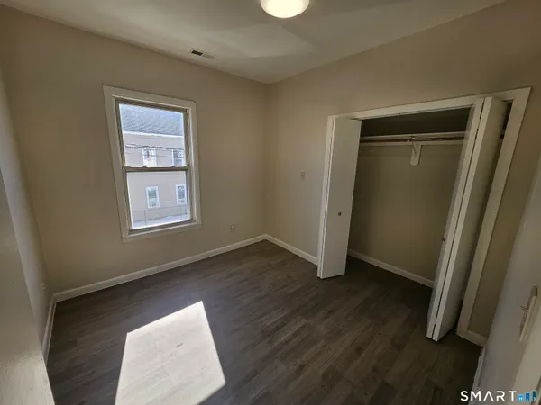 an empty room with wooden floor and a window
