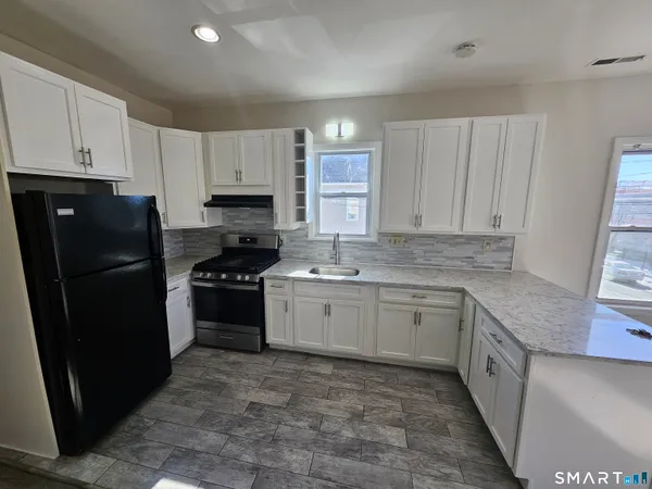 a kitchen with a refrigerator stove top oven and sink