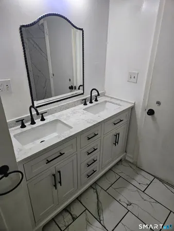a bathroom with a double vanity sink and mirror
