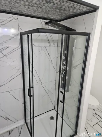 a bathroom with a glass door shower and vanity