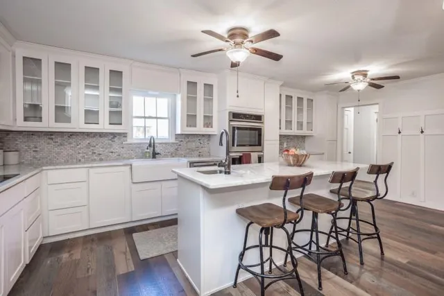 a kitchen with a dining table chairs cabinets and appliances