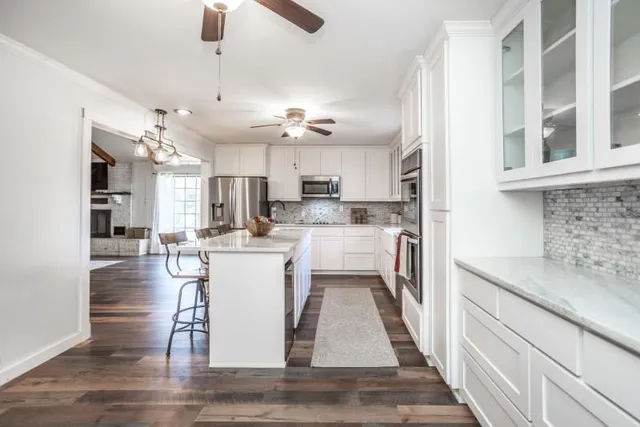 a kitchen with a refrigerator a sink dishwasher with a dining table and chairs