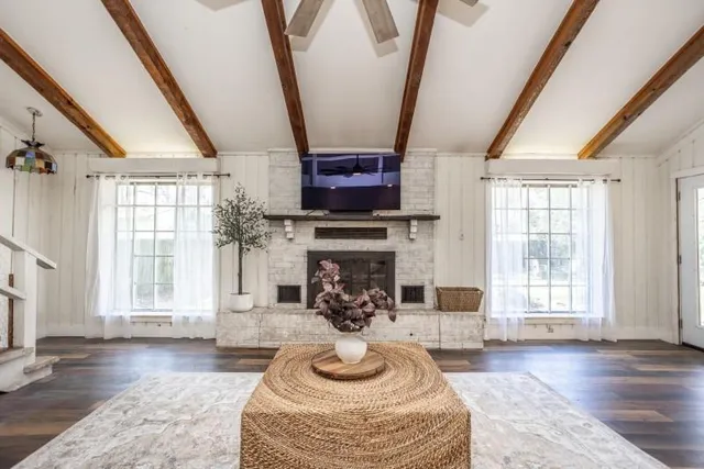a living room with furniture a fireplace and a floor to ceiling window