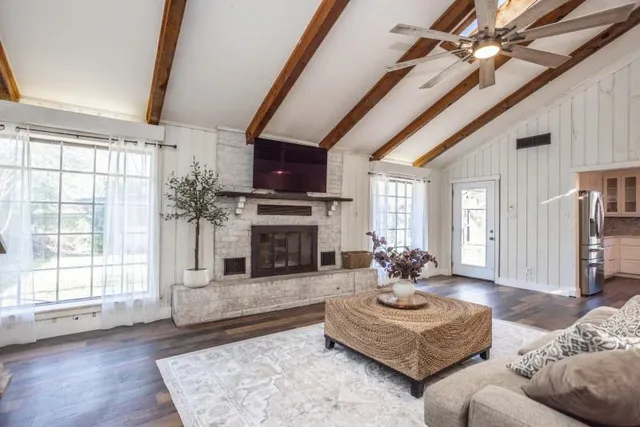 a living room with furniture large window and fireplace
