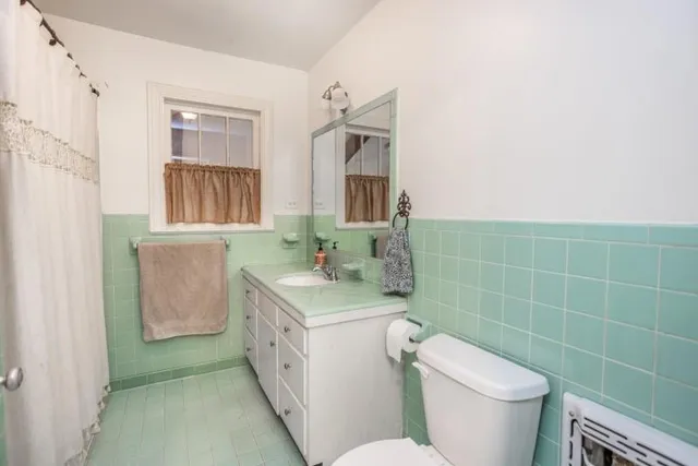 a bathroom with a granite countertop toilet sink and mirror