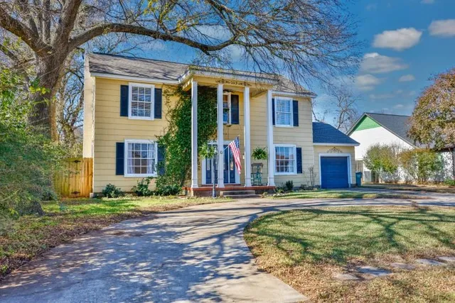 a view of brick house with a yard