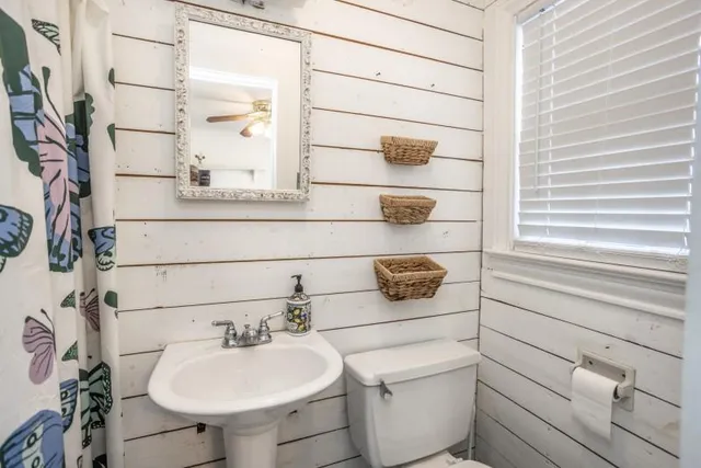 a bathroom with a sink toilet and mirror