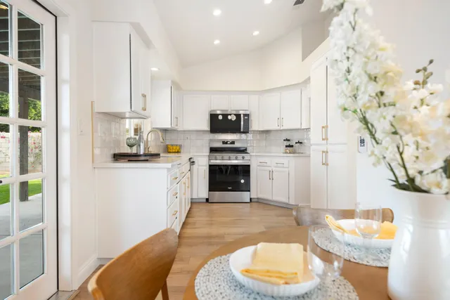 a kitchen with stainless steel appliances white cabinets and a stove top oven