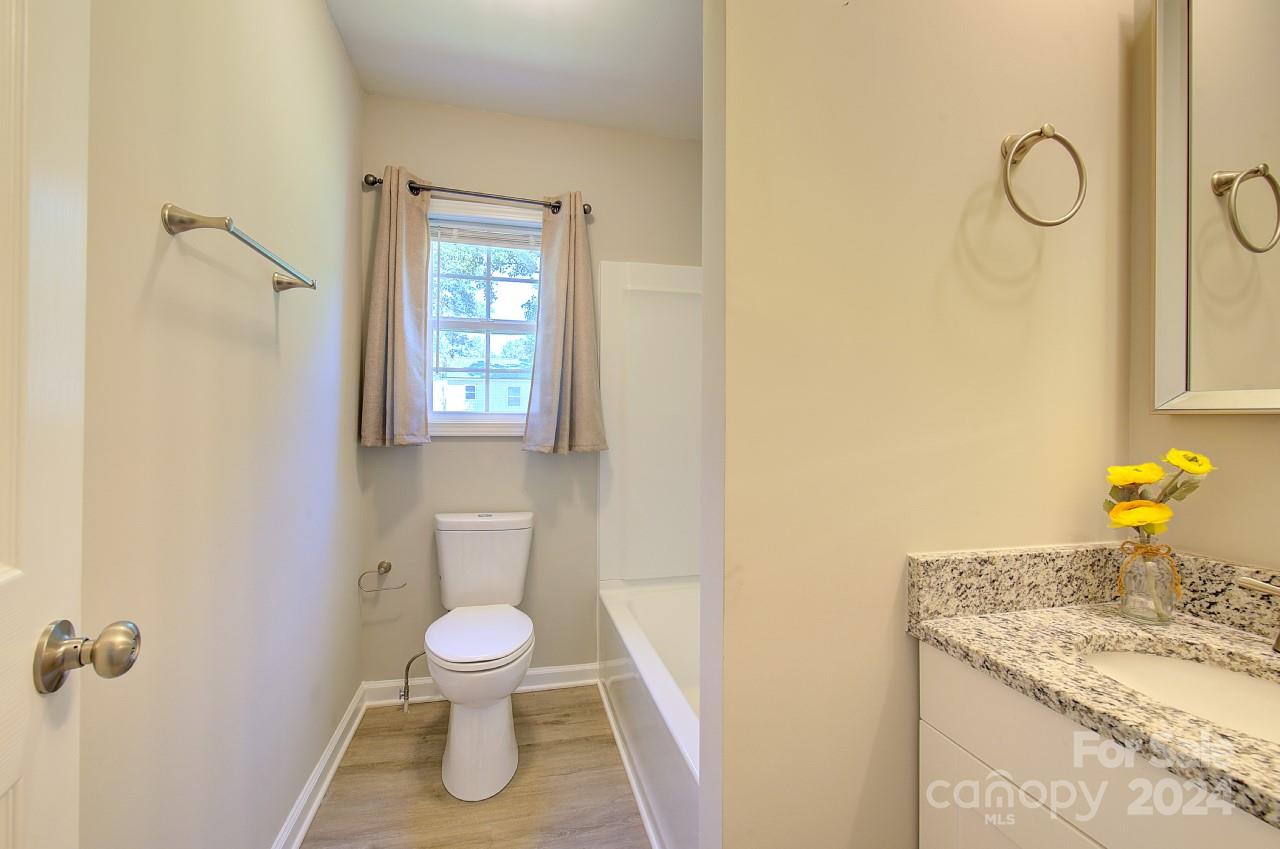 6130 Hopewell Road Hickory Grove, SC 29717 - Photo 17 of 29 a bathroom with a granite countertop toilet and a sink