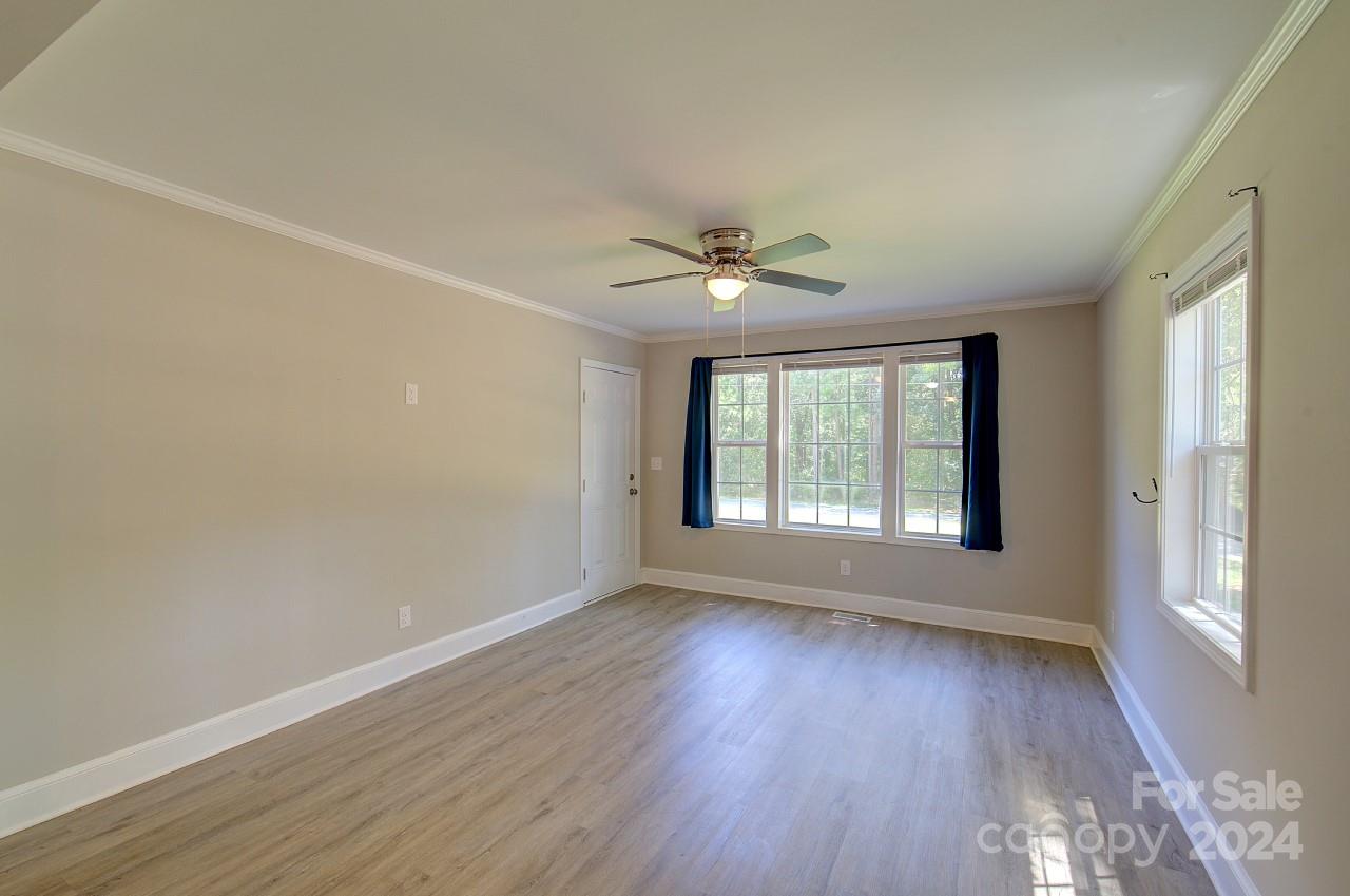 6130 Hopewell Road Hickory Grove, SC 29717 - Photo 4 of 29 a view of an empty room with wooden floor and a window