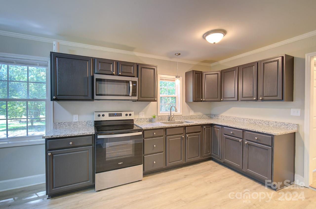 6130 Hopewell Road Hickory Grove, SC 29717 - Photo 7 of 29 a kitchen with stainless steel appliances granite countertop wooden cabinets a stove top oven a sink and dishwasher
