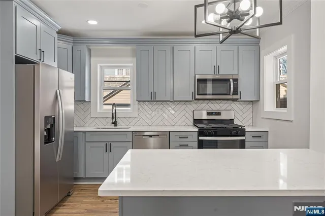 a kitchen with stainless steel appliances a refrigerator stove microwave and sink