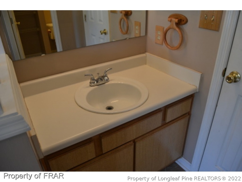 3326 Annawood Court Spring Lake, NC 28390 - Photo 12 of 19 a bathroom with a sink and a mirror