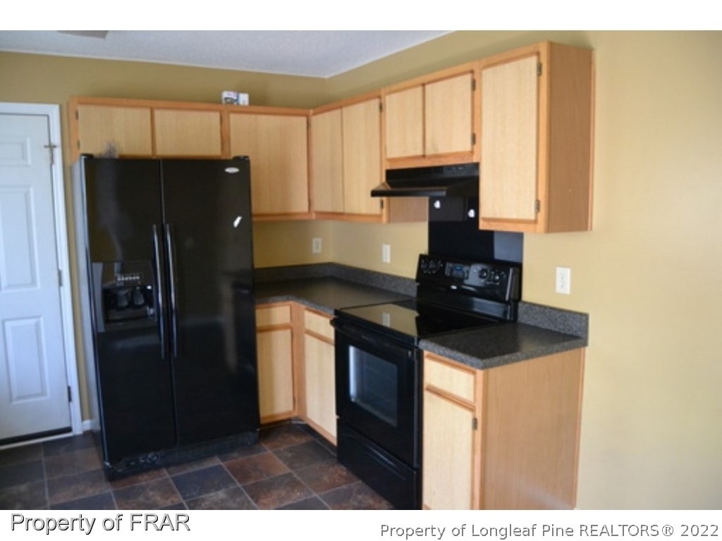 3326 Annawood Court Spring Lake, NC 28390 - Photo 5 of 19 a kitchen with kitchen island granite countertop a refrigerator a stove top oven