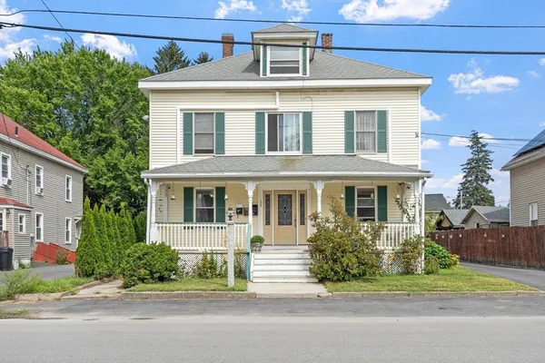 a front view of a house with a garden and plants