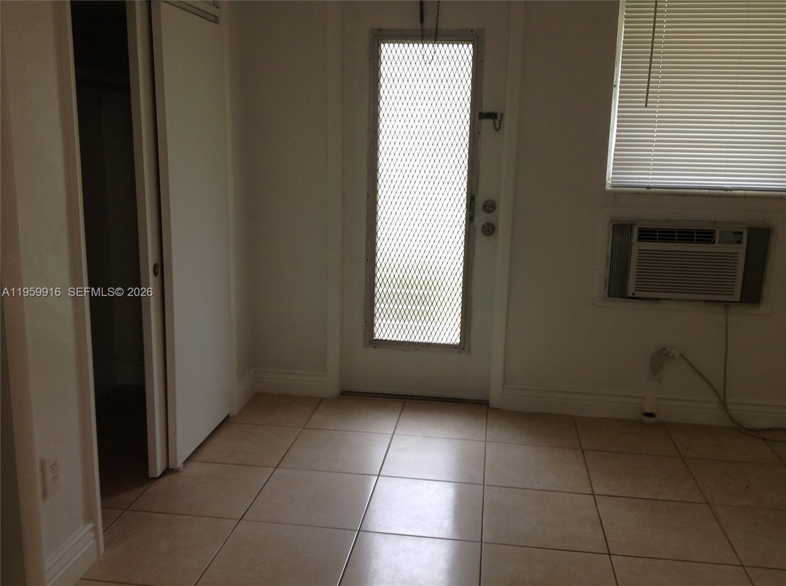 280 Southwest 11th Avenue, Unit 5 Hallandale Beach, FL 33009 - Photo 3 of 9 a view of an empty room with a window