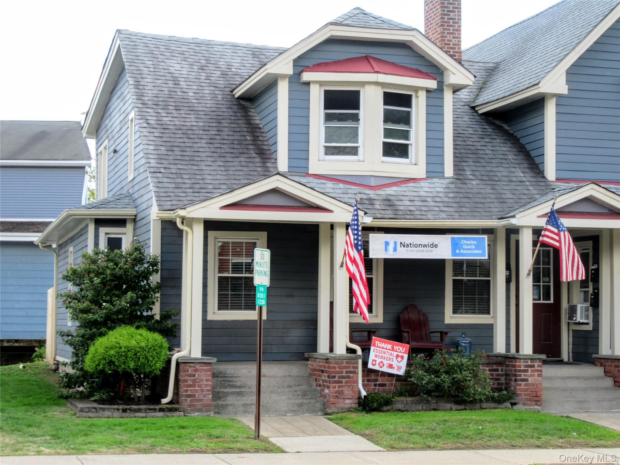 View of front of home featuring a chimney, a shingled roof, and cooling unit