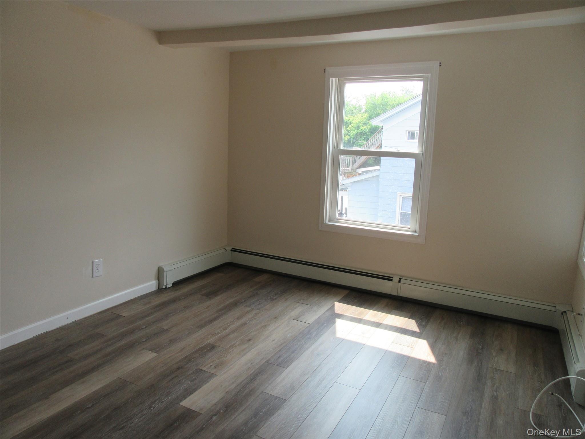 13 West Main Street, Unit 2A Washingtonville, NY 10992 - Photo 2 of 13 Unfurnished room with dark wood-style flooring and a baseboard radiator