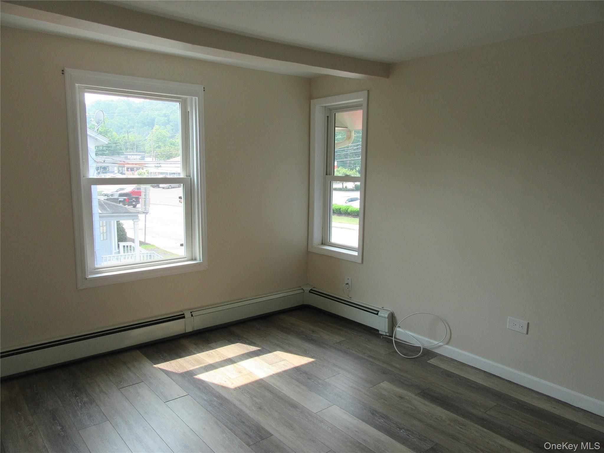 13 West Main Street, Unit 2A Washingtonville, NY 10992 - Photo 3 of 13 Empty room featuring a baseboard heating unit, wood finished floors, and beamed ceiling