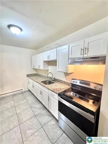 a kitchen with stainless steel appliances granite countertop a sink stove and cabinets