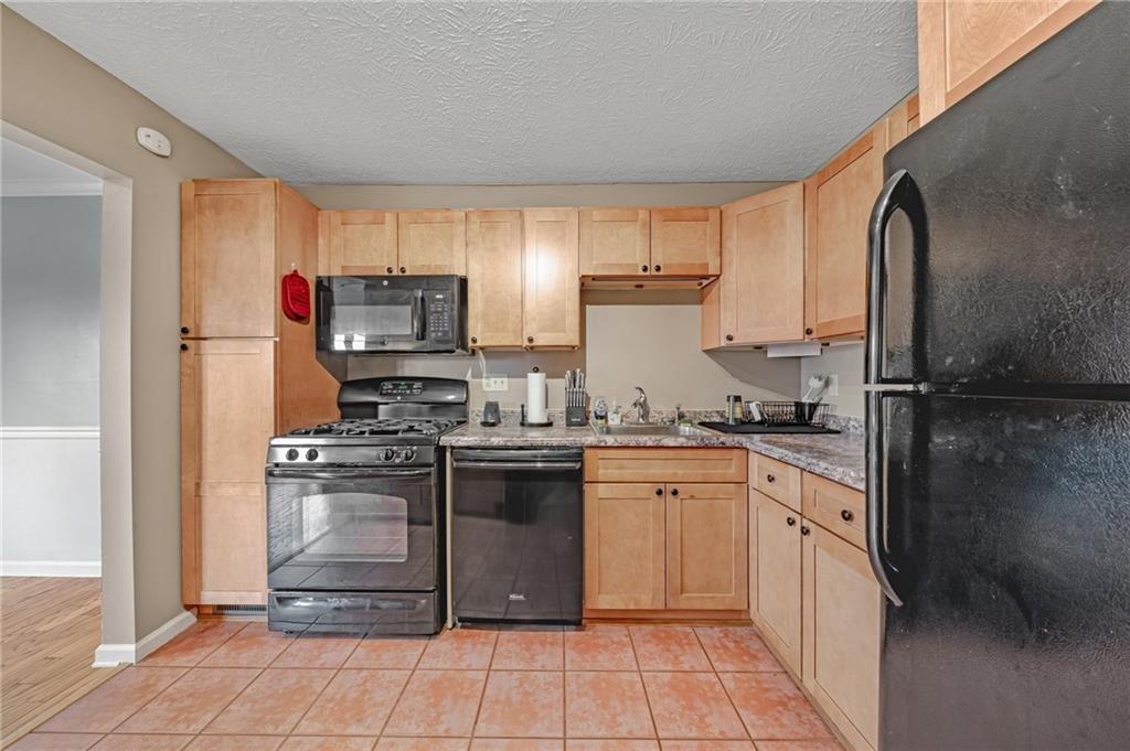 661 Georgetown Village Indiana, PA 15701 - Photo 4 of 25 a kitchen with stainless steel appliances granite countertop a sink stove refrigerator and cabinets
