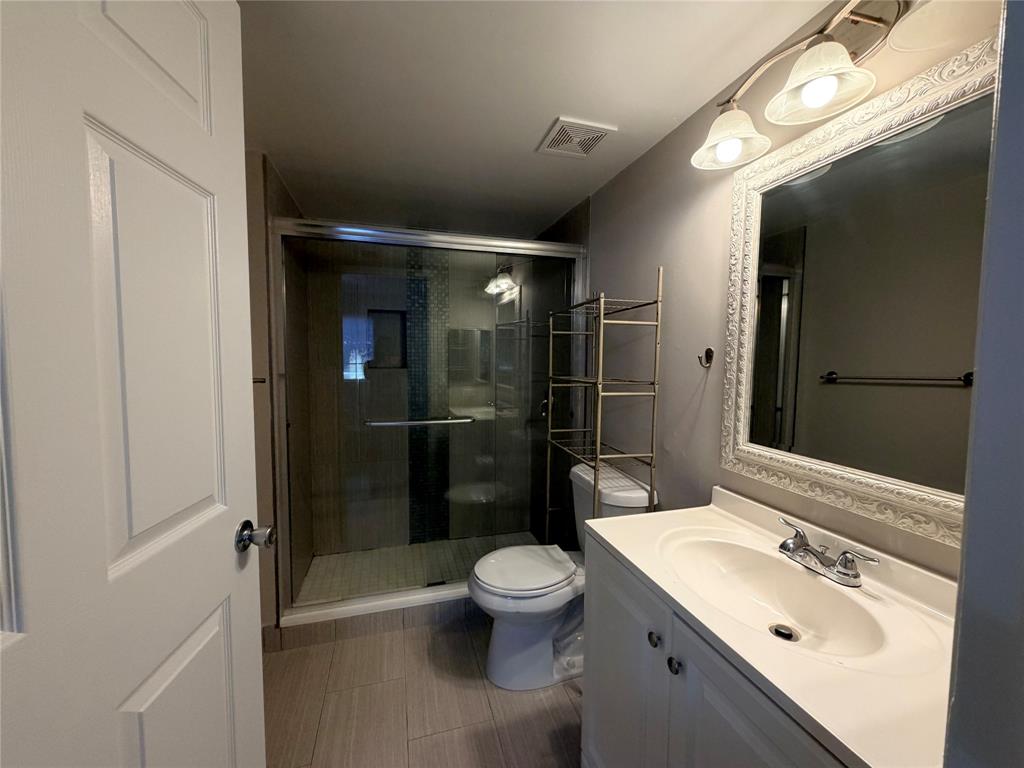 5025 Wiles Road, Unit 101 Coconut Creek, FL 33073 - Photo 14 of 27 a bathroom with a sink toilet a shower and a mirror