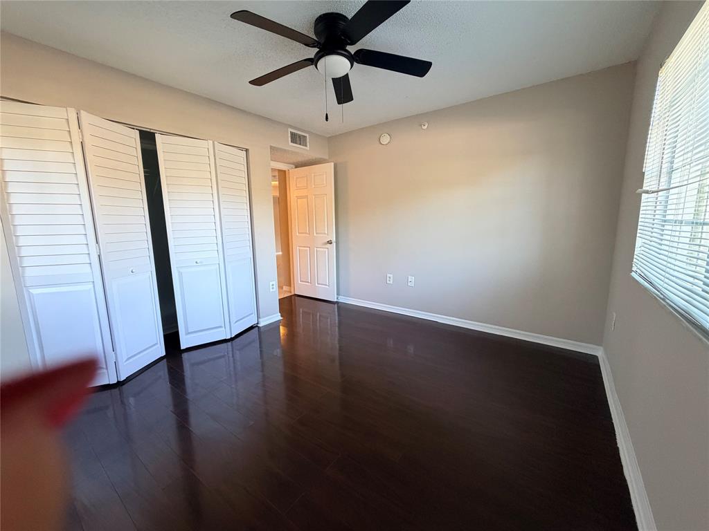 5025 Wiles Road, Unit 101 Coconut Creek, FL 33073 - Photo 16 of 27 a view of an empty room with wooden floor and a window
