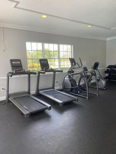 5025 Wiles Road, Unit 101 Coconut Creek, FL 33073 - Photo 25 of 27 a room with gym equipment and a large window