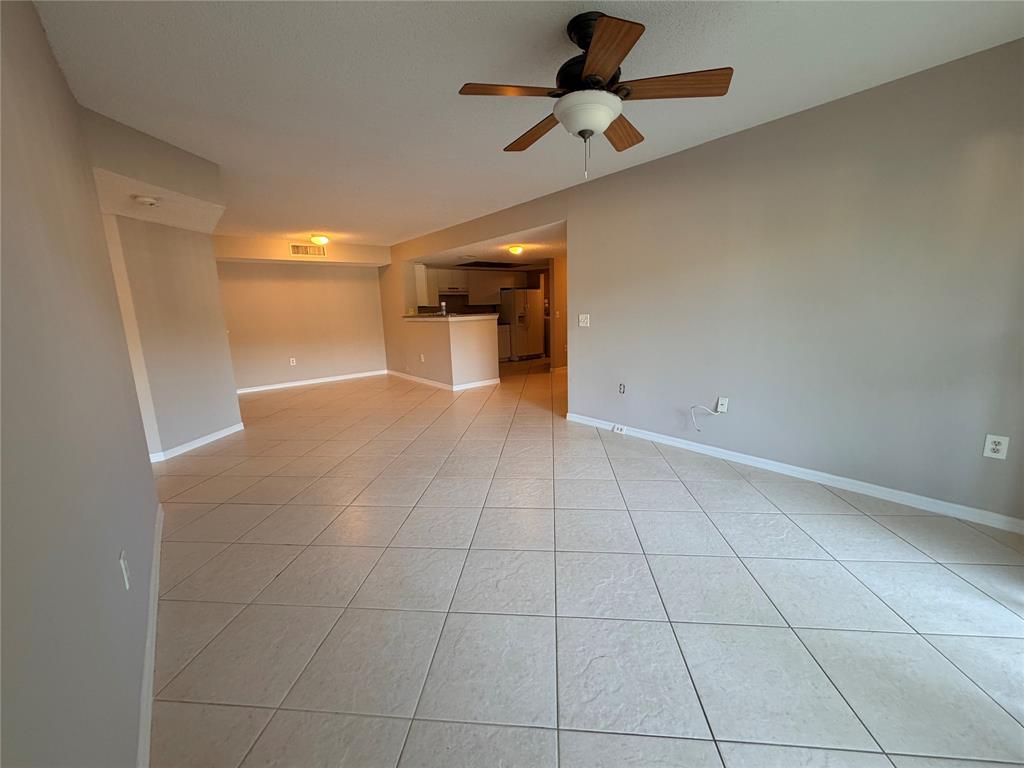 5025 Wiles Road, Unit 101 Coconut Creek, FL 33073 - Photo 6 of 27 a view of a livingroom with a ceiling fan and window