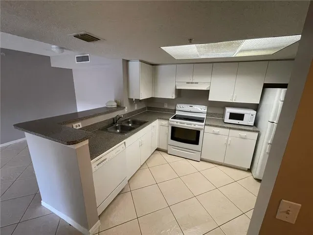 a kitchen with granite countertop a stove and a sink