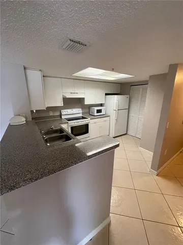 a kitchen with stainless steel appliances a sink a stove top oven a counter space and cabinets