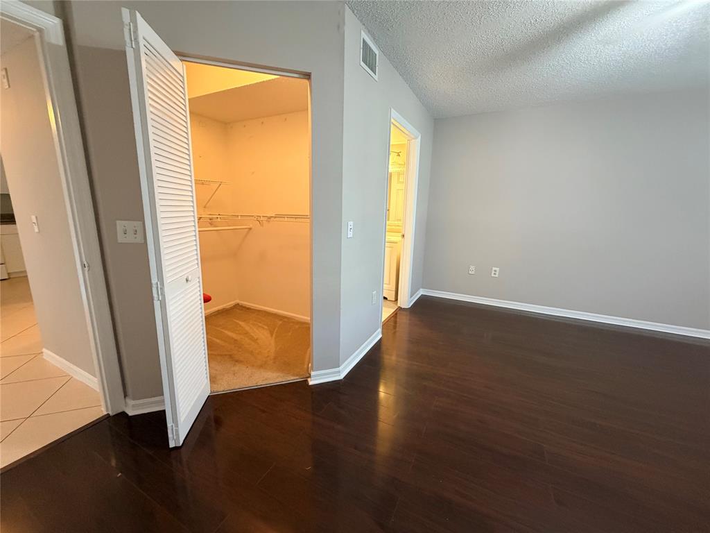 5025 Wiles Road, Unit 101 Coconut Creek, FL 33073 - Photo 9 of 27 a view of an empty room with wooden floor and a window