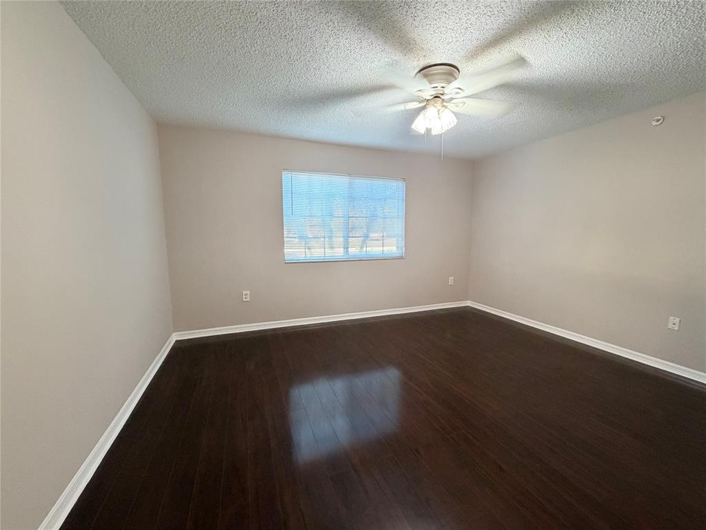 5025 Wiles Road, Unit 101 Coconut Creek, FL 33073 - Photo 10 of 27 an empty room with wooden floor and windows