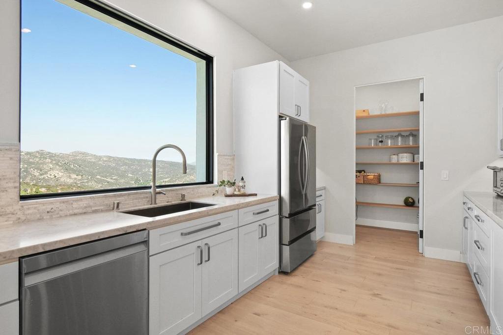 573 Lilac Ranch Road Alpine, CA 91901 - Photo 12 of 47 a kitchen with stainless steel appliances a sink cabinets and a refrigerator