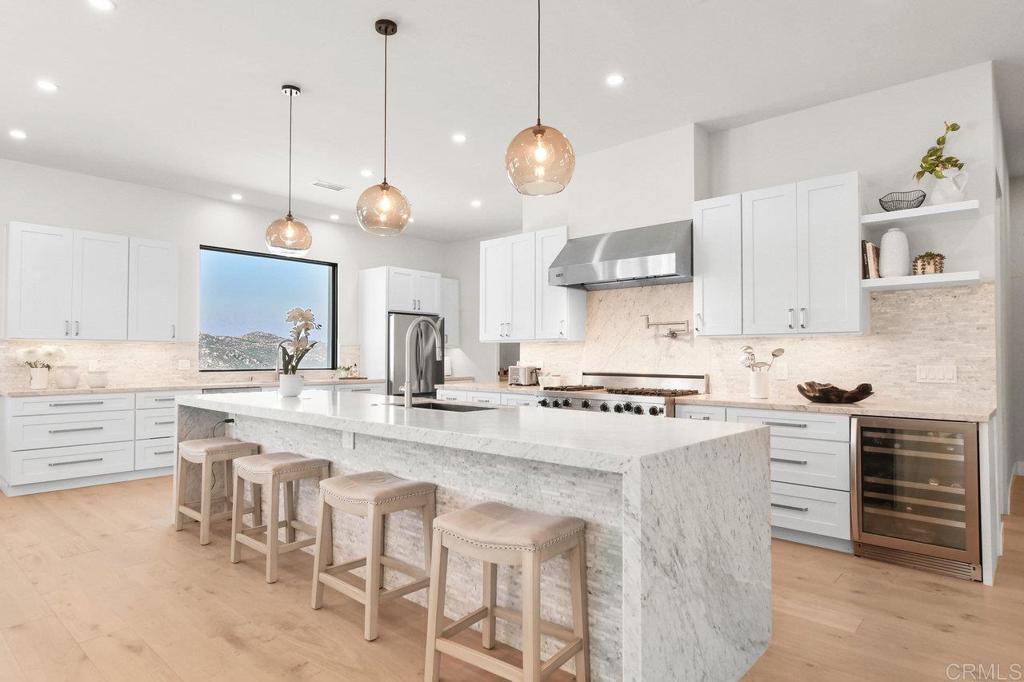 573 Lilac Ranch Road Alpine, CA 91901 - Photo 9 of 47 a kitchen with kitchen island granite countertop a sink a stove and a oven