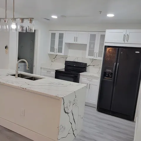 a kitchen with stainless steel appliances a refrigerator sink and wooden floor