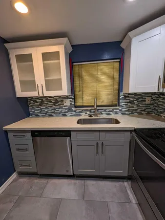 a kitchen with granite countertop a sink and a stove