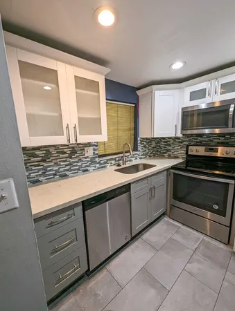a kitchen with granite countertop a stove and a sink