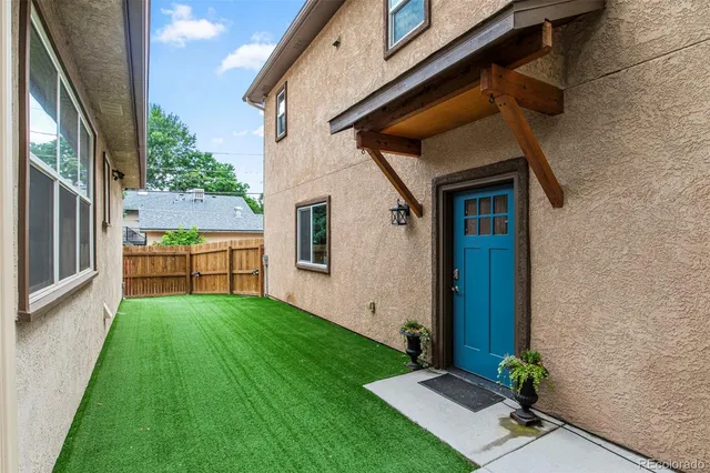 a backyard of a house with table and sofas