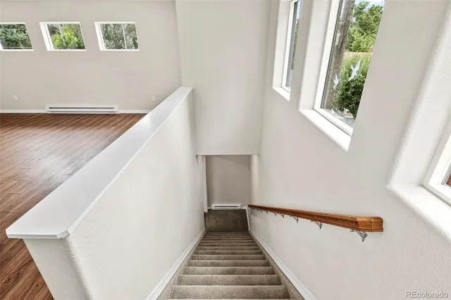 a kitchen with stainless steel appliances granite countertop a sink a stove and a wooden floors