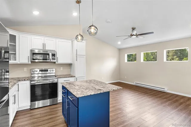 a kitchen with stainless steel appliances granite countertop a sink stove microwave and refrigerator