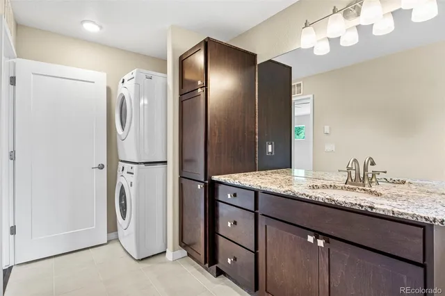 a bathroom with a granite countertop sink a toilet a mirror and shower