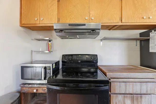 a stove top oven sitting inside of a kitchen