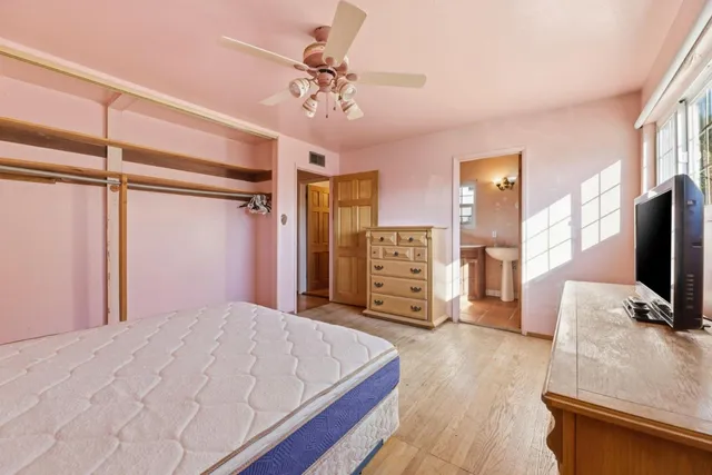 a bedroom with a bed and a flat tv screen on dresser