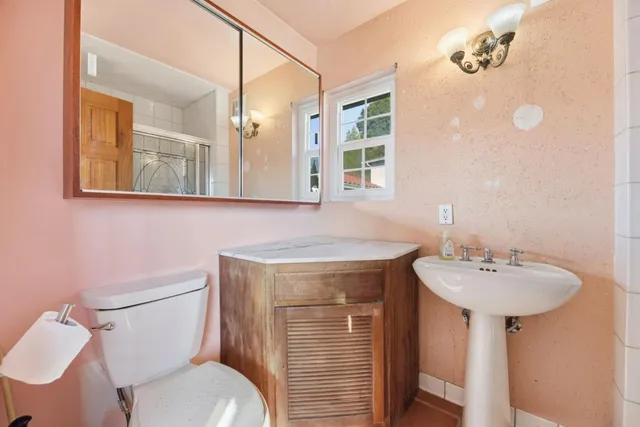 a bathroom with a toilet a sink and mirror