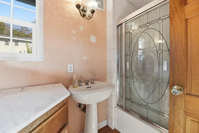 a bathroom with a sink a mirror and shower