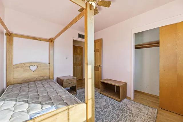 a spacious bedroom with a bed and a chandelier