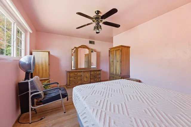a bedroom with bed and wooden floor