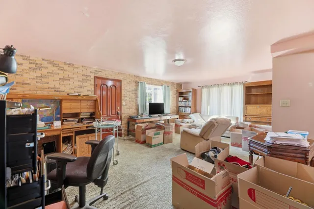 a living room with furniture fireplace and a large window